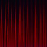 Zdjęcie ukazujące szkarłatną kurtynę na scenie teatru.